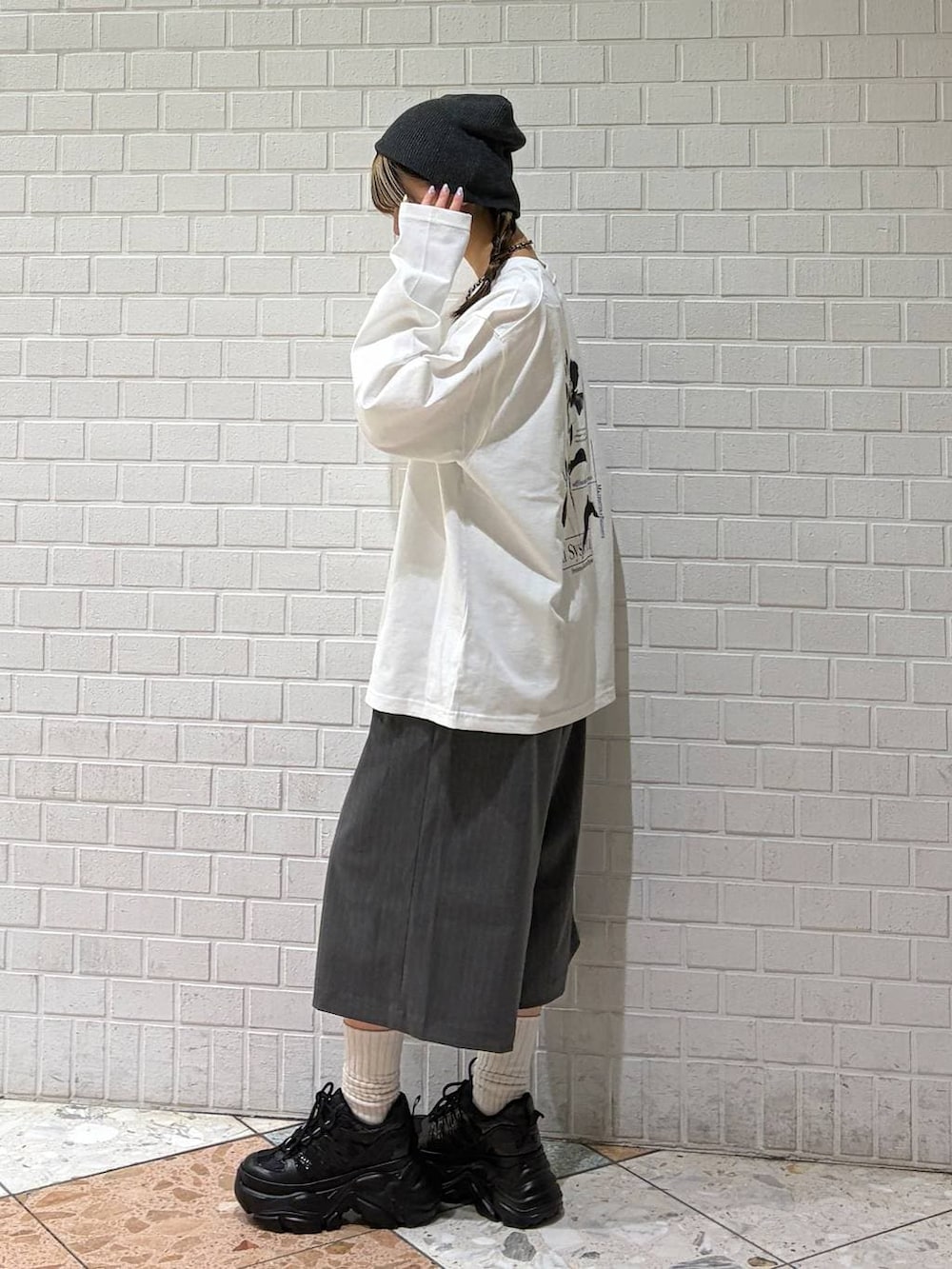 ブラック系のスニーカー、ホワイト系のTシャツ/カットソー、グレー系のスラックスを着用したレディースの春コーディネートの7枚目の写真