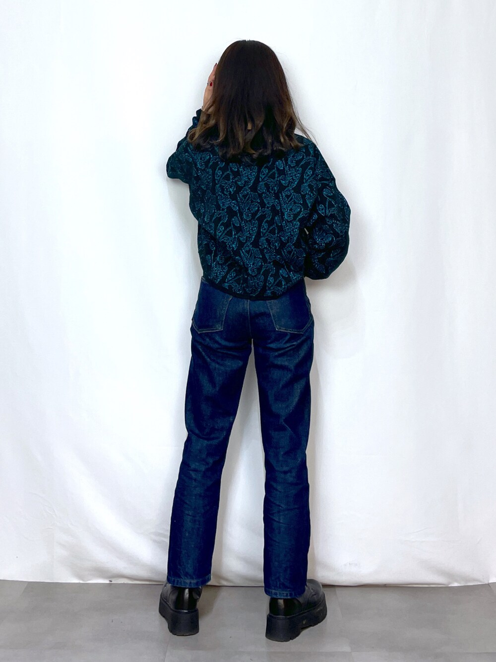 ブラック系のニット/セーター、ブルー系のデニムパンツ、ブラック系のベルトを着用したレディースの冬コーディネートの3枚目の写真