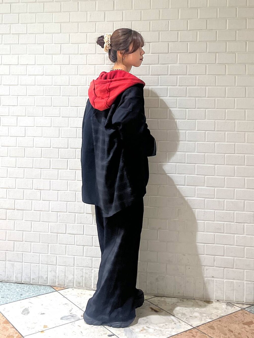 ブラック系のブーツ、グレー系のボストンバッグ、ブラック系のスラックスを着用したレディースの秋コーディネートの8枚目の写真