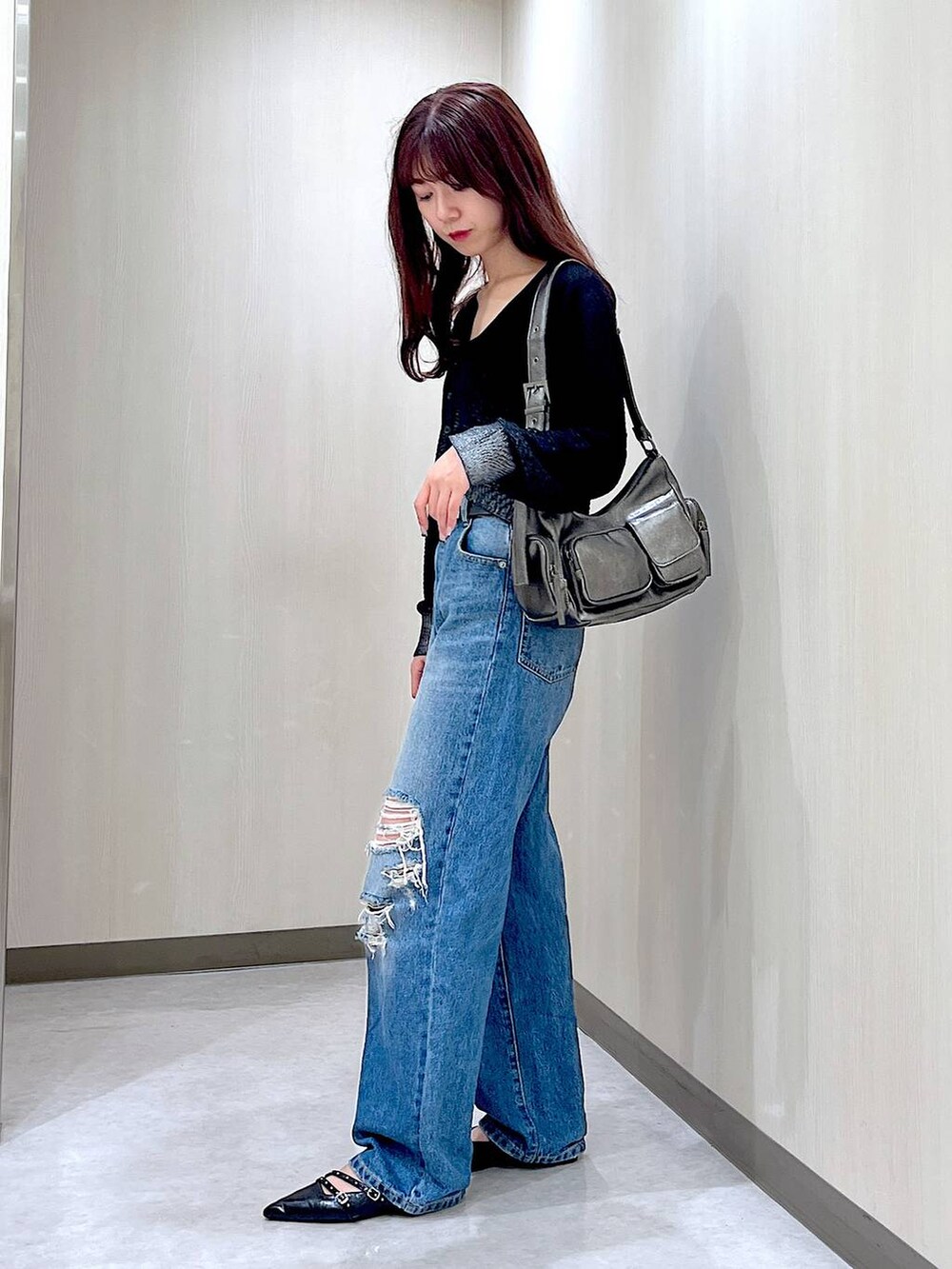 ブラック系のパンプス、ブルー系のデニムパンツ、ブラック系のカーディガン/ボレロを着用したレディースの秋コーディネートの2枚目の写真