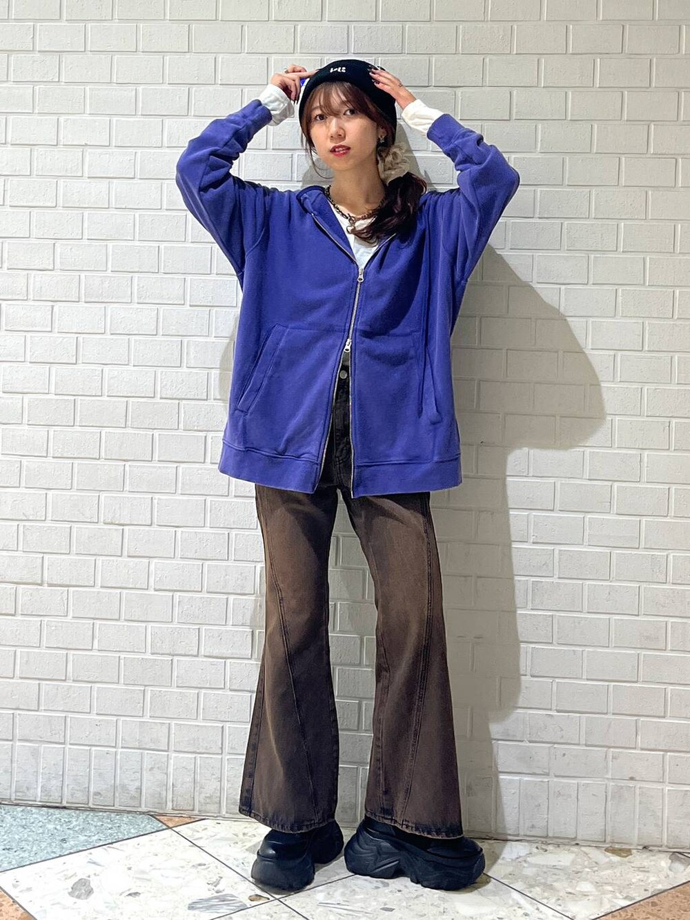 ブラック系のブーツ、ブラウン系のデニムパンツ、ブルー系のパーカーを着用したレディースの秋コーディネートの6枚目の写真