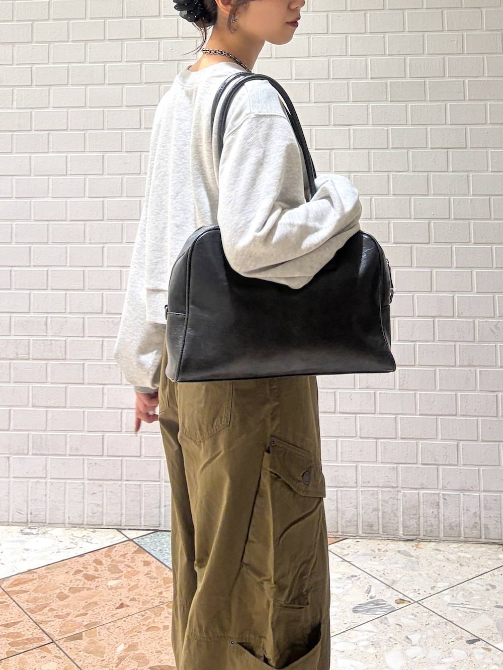 グレー系のスウェット、グリーン系のカーゴパンツ、ブラック系のブーツを着用したレディースの秋コーディネートの8枚目の写真