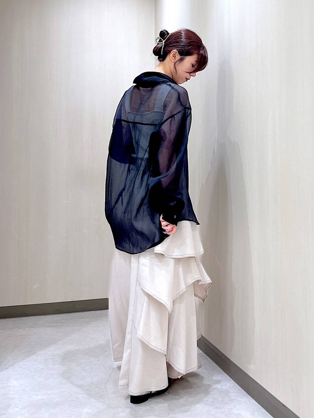 ブラック系のパンプス、ブラック系のシャツ/ブラウス、グレー系のスカートを着用したレディースの秋コーディネートの6枚目の写真