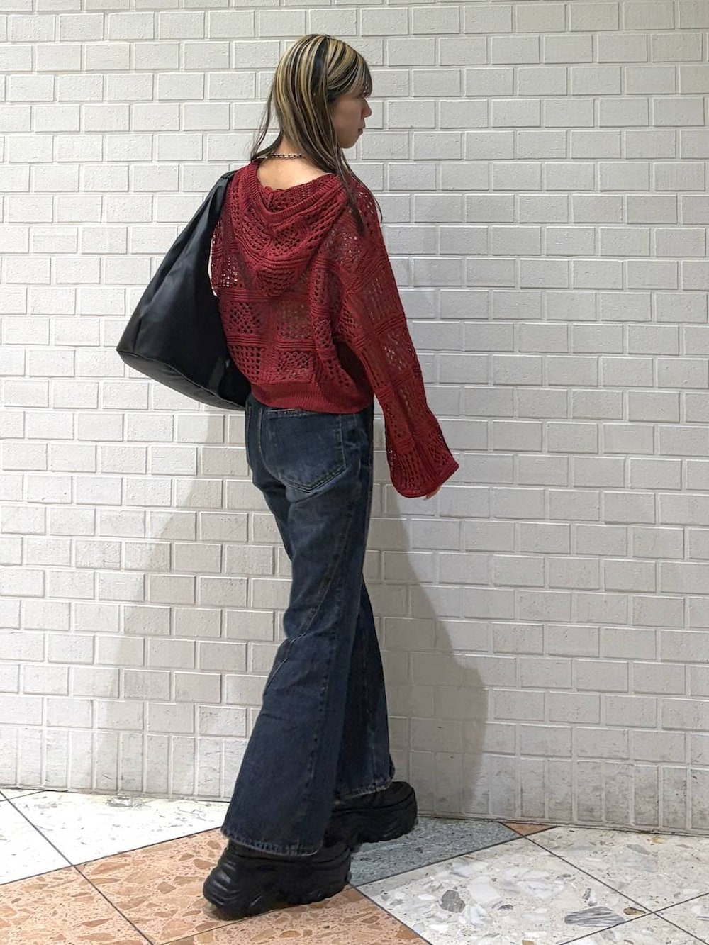 ブラック系のスニーカー、ブルー系のデニムパンツ、ブラック系のトートバッグを着用したレディースの春コーディネートの5枚目の写真