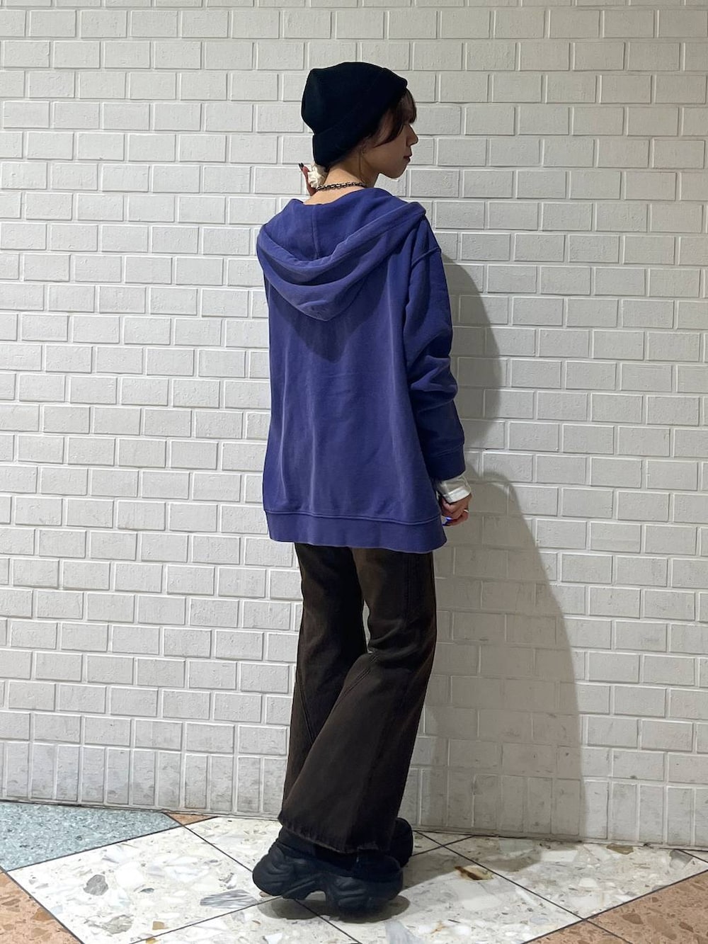 ブラック系のブーツ、ブラウン系のデニムパンツ、ブルー系のパーカーを着用したレディースの秋コーディネートの5枚目の写真