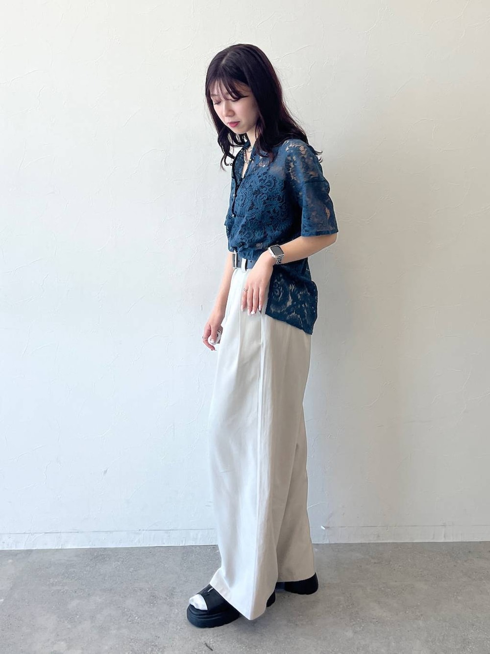 グリーン系のシャツ/ブラウス、ベージュ系のスラックス、ブラック系のベルトを着用したレディースの春コーディネートの2枚目の写真