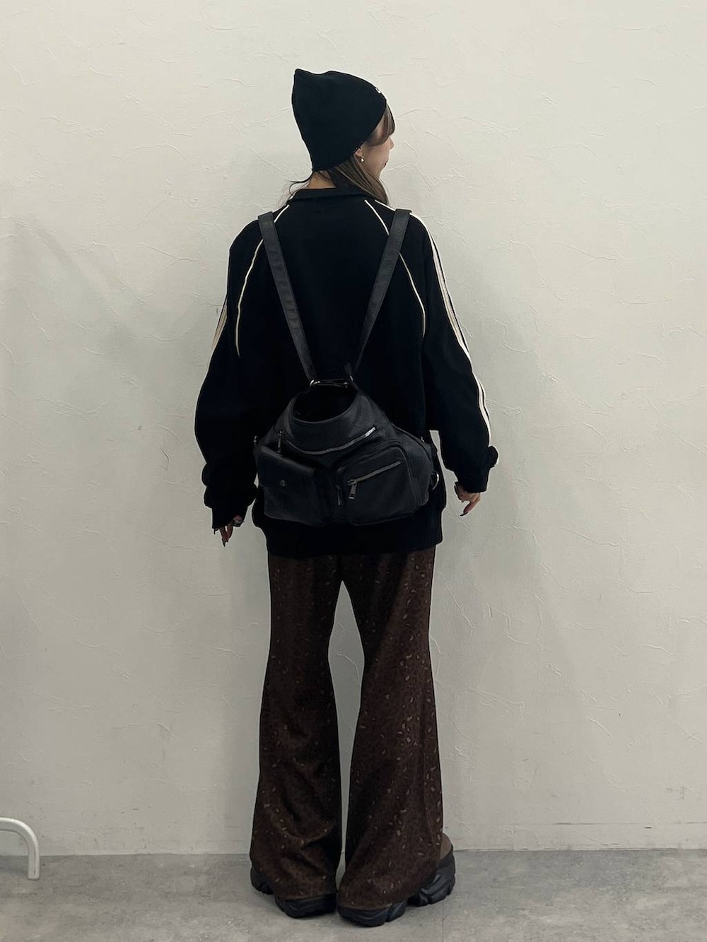 ブラウン系のブーツ、ブラック系のショルダーバッグ、ブラック系のジャージを着用したレディースの冬コーディネートの3枚目の写真