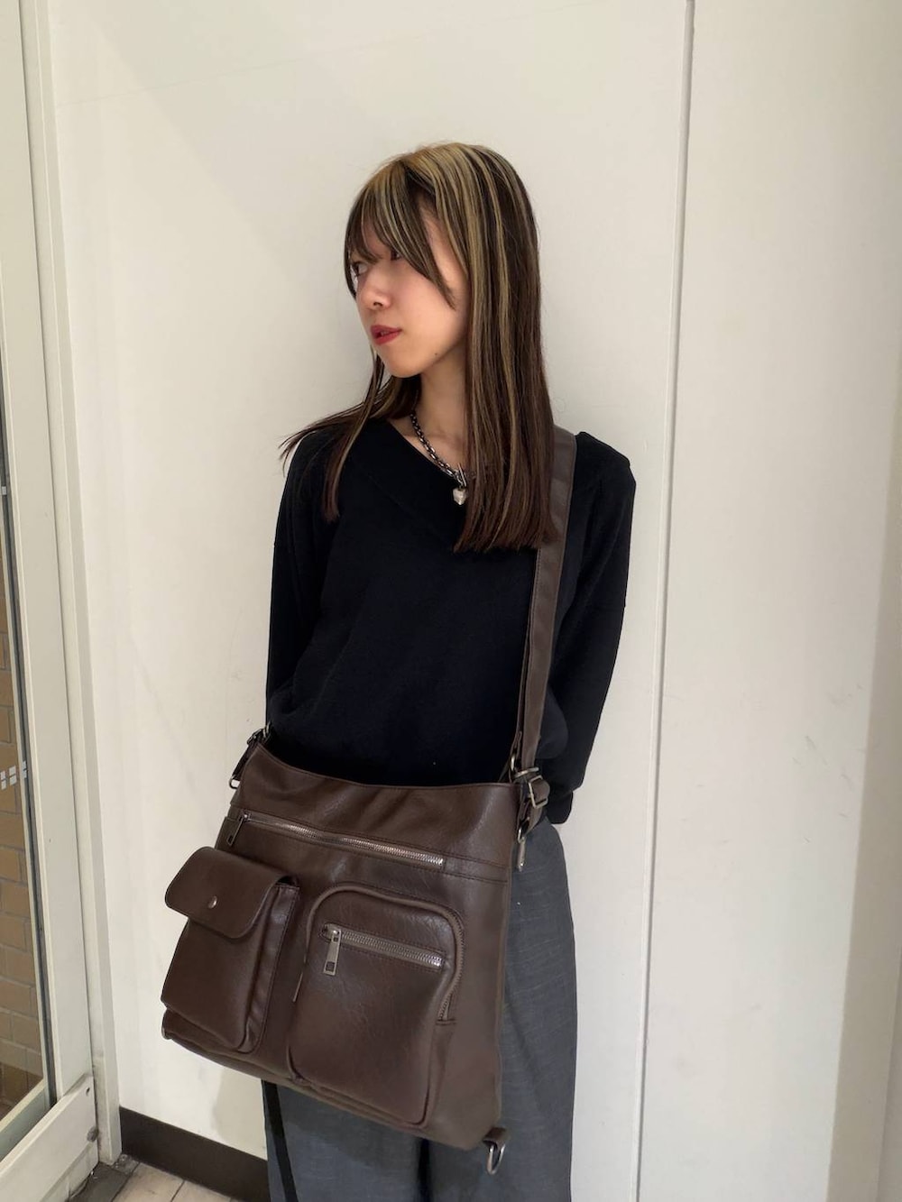 ブラック系のブーツ、ブラック系のニット/セーター、ブラウン系のショルダーバッグを着用したレディースの冬コーディネートの5枚目の写真