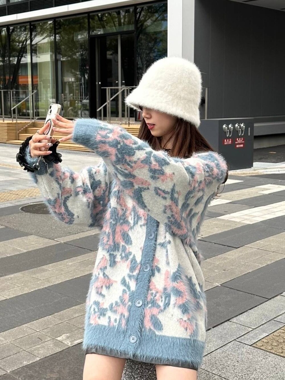 ブラック系のブーツ、ホワイト系のニット/セーター、ブラック系のスカートを着用したレディースの秋コーディネートの2枚目の写真