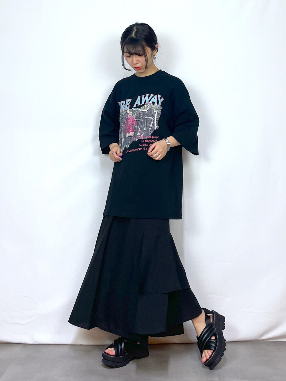 ブラック系のTシャツ/カットソー、ブラック系のスカート、ブラック系のサンダルを着用したレディースの春コーディネートの2枚目の写真
