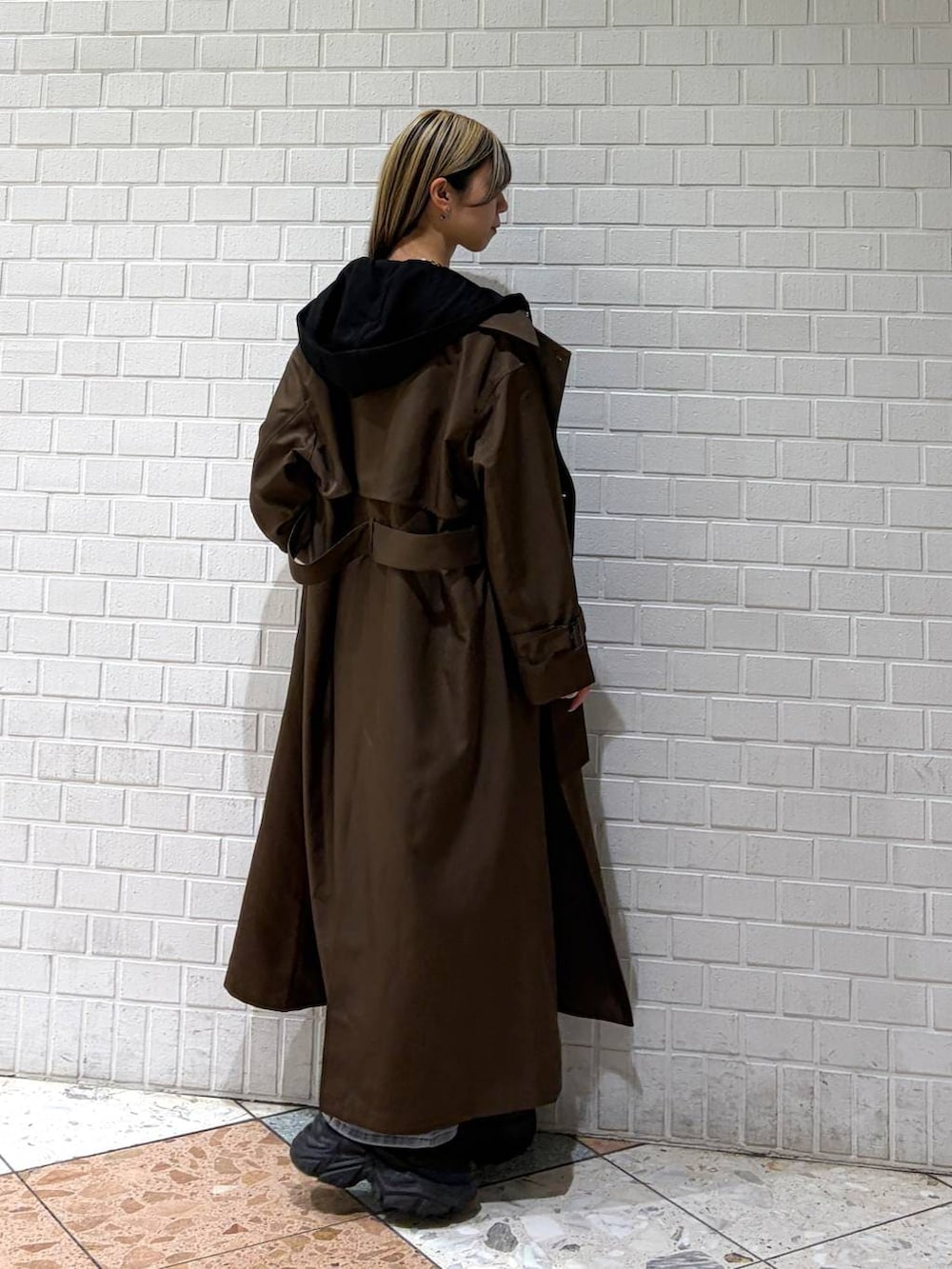 ブラック系のブーツ、ブラウン系のトレンチコート、ブルー系のデニムパンツを着用したレディースの春コーディネートの6枚目の写真