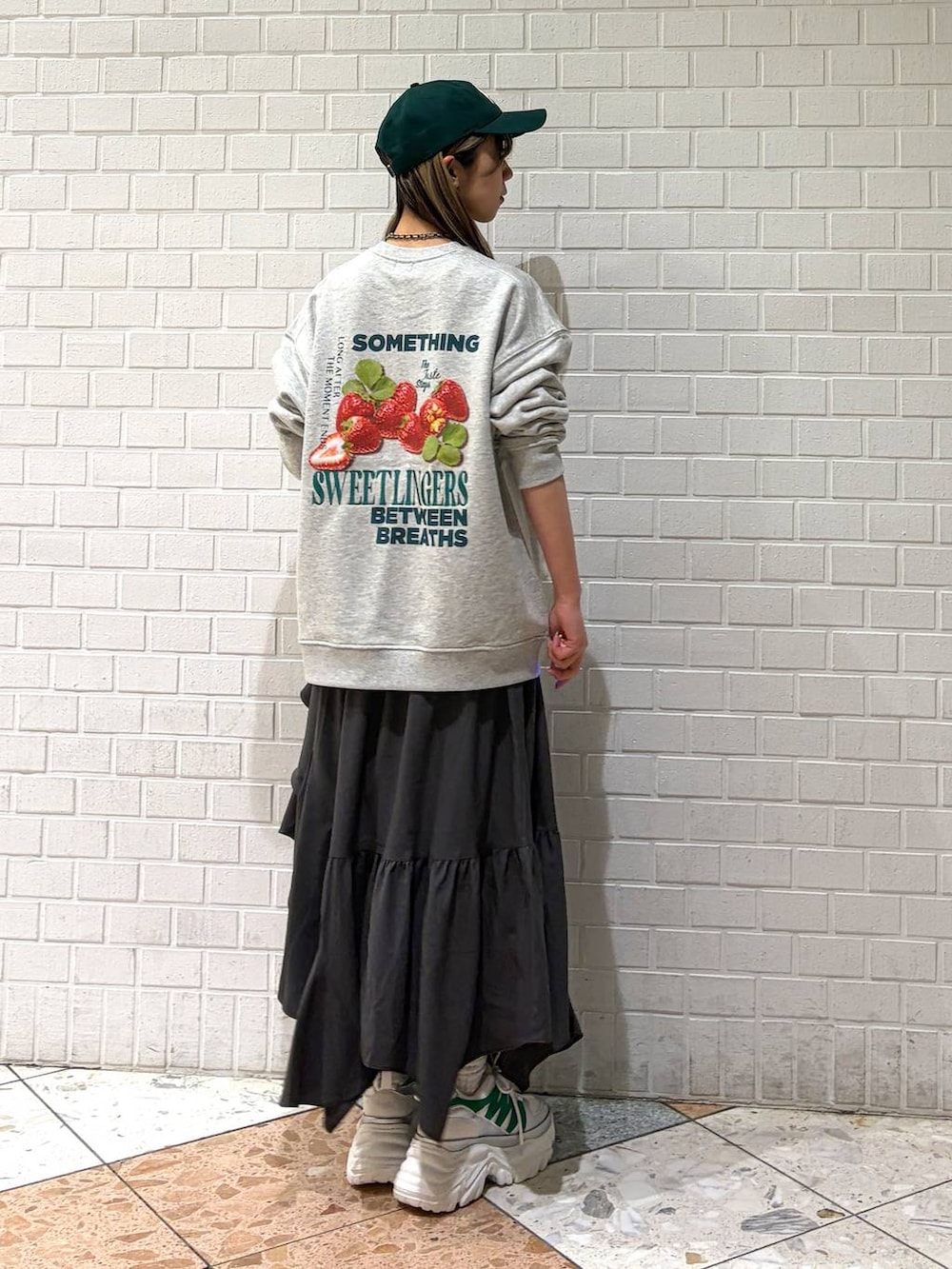 ホワイト系のスニーカー、グレー系のスカート、グレー系のスウェットを着用したレディースの春コーディネートの2枚目の写真