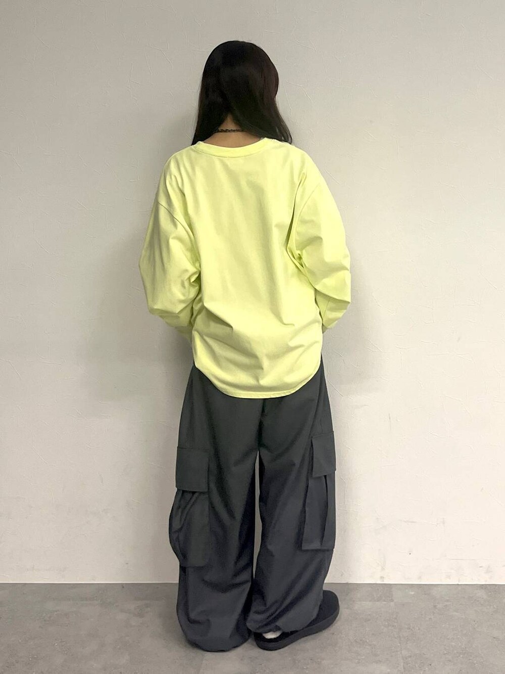 グレー系のカーゴパンツ、イエロー系のTシャツ/カットソー、ブラック系のネックレスを着用したレディースの冬コーディネートの4枚目の写真