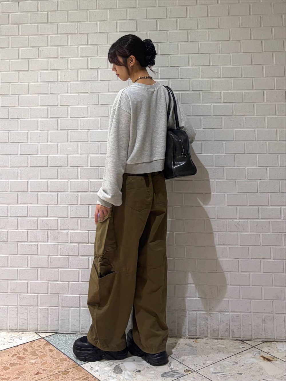 グレー系のスウェット、グリーン系のカーゴパンツ、ブラック系のブーツを着用したレディースの秋コーディネートの5枚目の写真