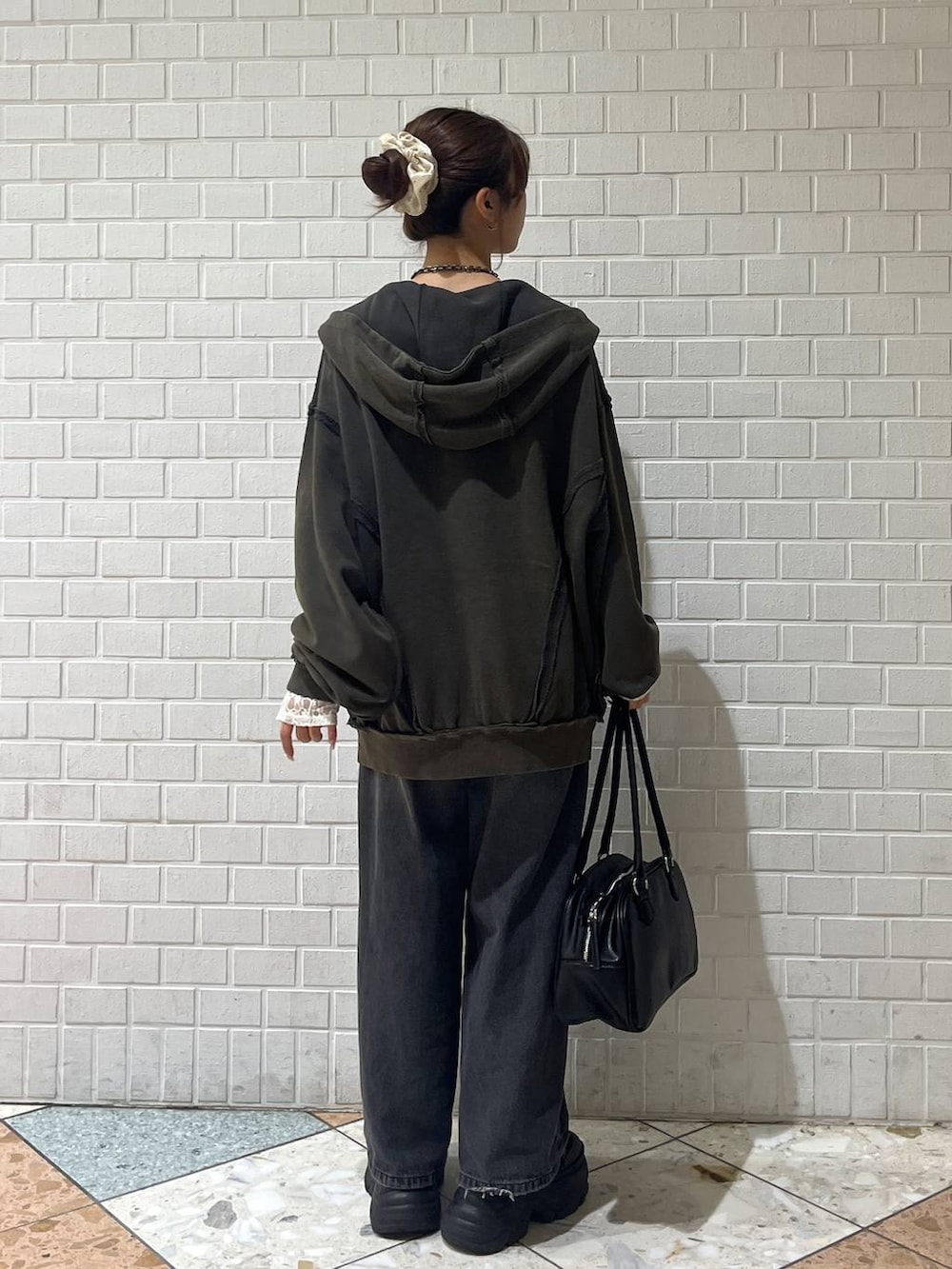 ブラック系のブーツ、ブラック系のデニムパンツ、ホワイト系のTシャツ/カットソーを着用したレディースの秋コーディネートの3枚目の写真