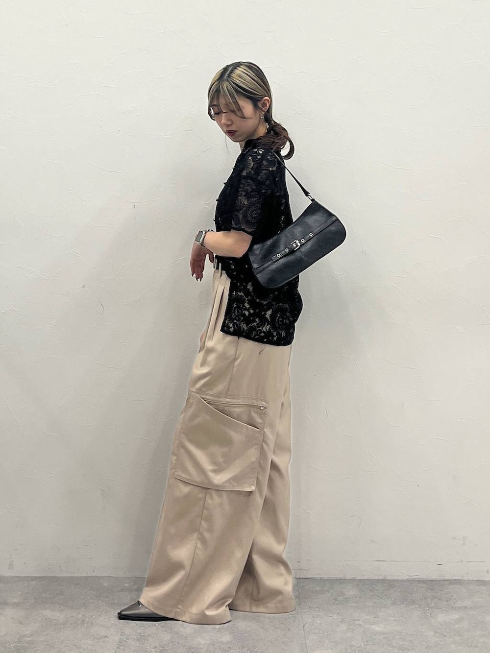 ブラック系のシャツ/ブラウス、ベージュ系のスラックス、ブラック系のハンドバッグを着用したレディースの春コーディネートの3枚目の写真