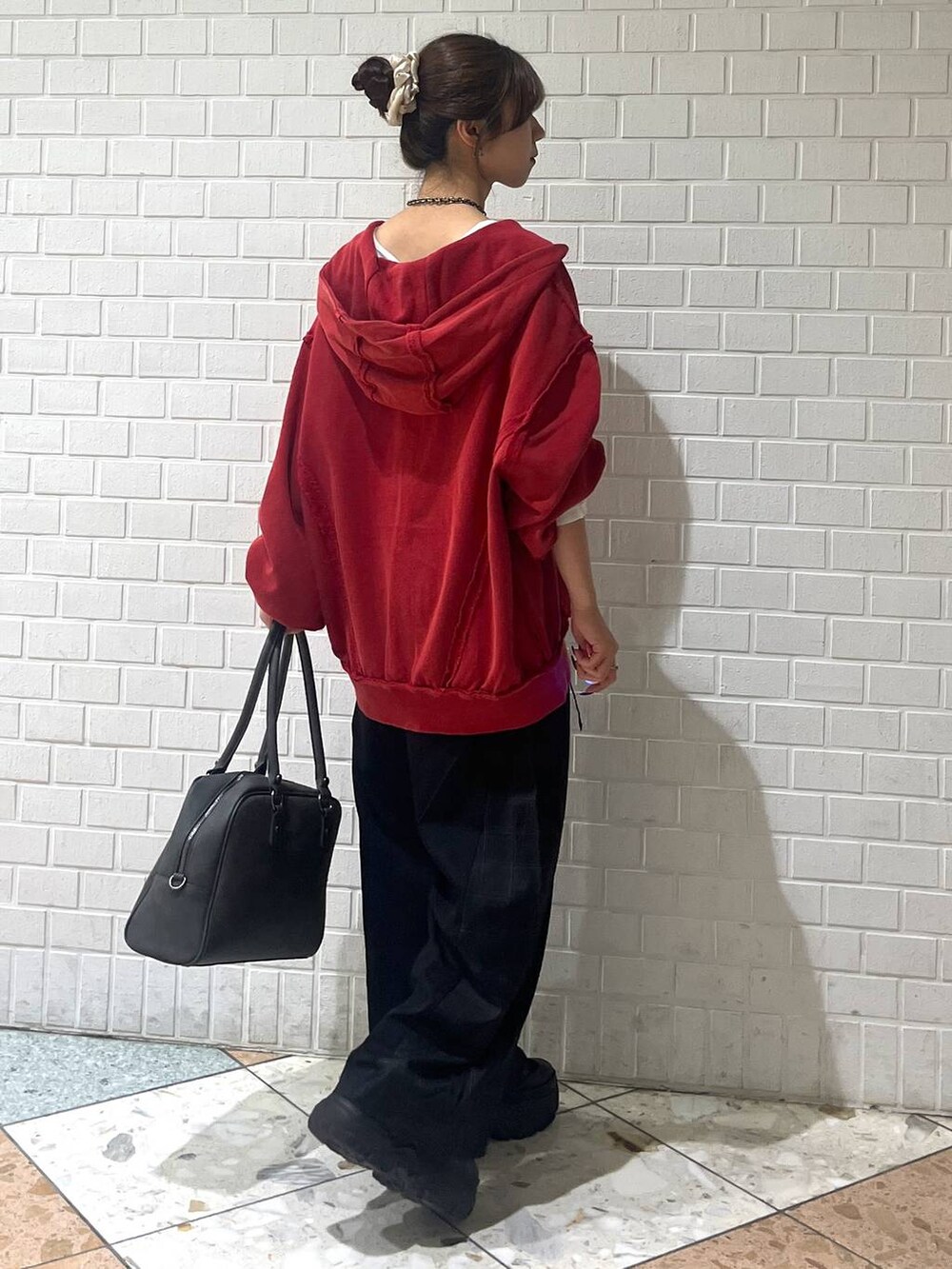 ブラック系のブーツ、グレー系のボストンバッグ、ブラック系のスラックスを着用したレディースの秋コーディネートの3枚目の写真