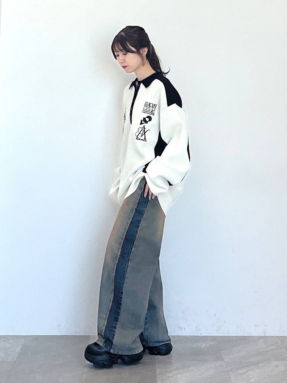 ブルー系のデニムパンツ、ブラック系のブーツ、ブラック系のニット/セーターを着用したレディースの秋コーディネートの3枚目の写真