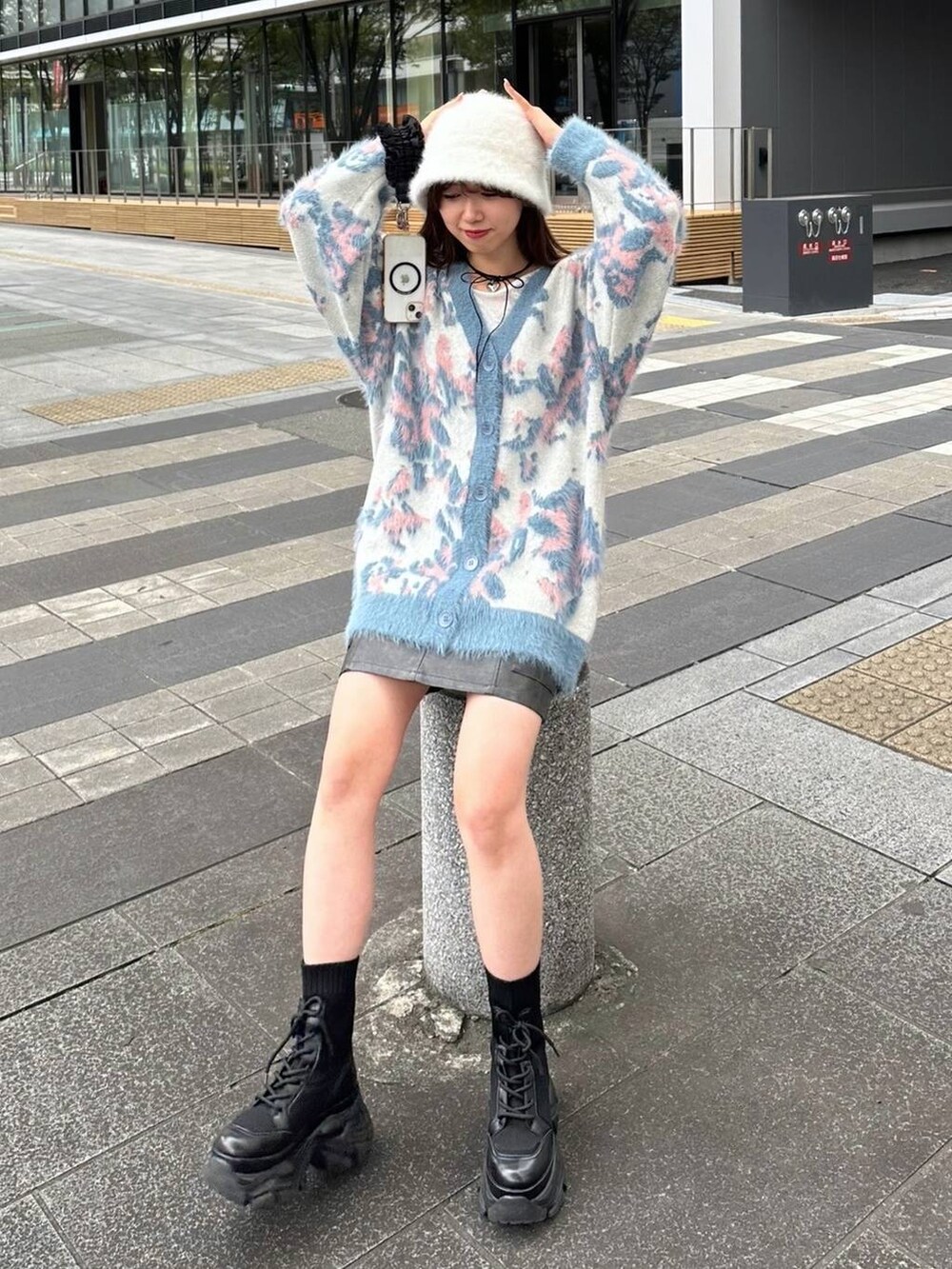 ブラック系のブーツ、ホワイト系のニット/セーター、ブラック系のスカートを着用したレディースの秋コーディネートの3枚目の写真