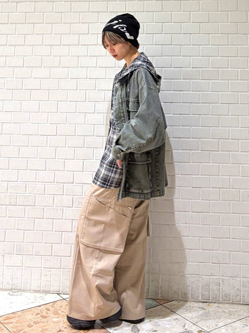 ブラック系のブーツ、ベージュ系のスラックス、ブラック系のシャツ/ブラウスを着用したレディースの春コーディネートの2枚目の写真