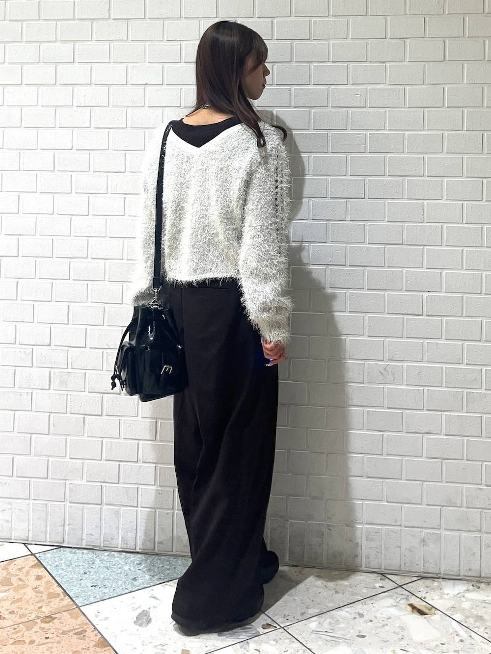 ブラック系のスニーカー、ブラック系のブルゾン、ホワイト系のカーディガン/ボレロを着用したレディースの秋コーディネートの5枚目の写真