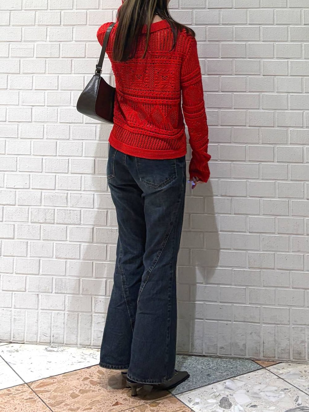 ブルー系のデニムパンツ、ブラウン系のハンドバッグ、ブラウン系のサンダルを着用したレディースの春コーディネートの6枚目の写真