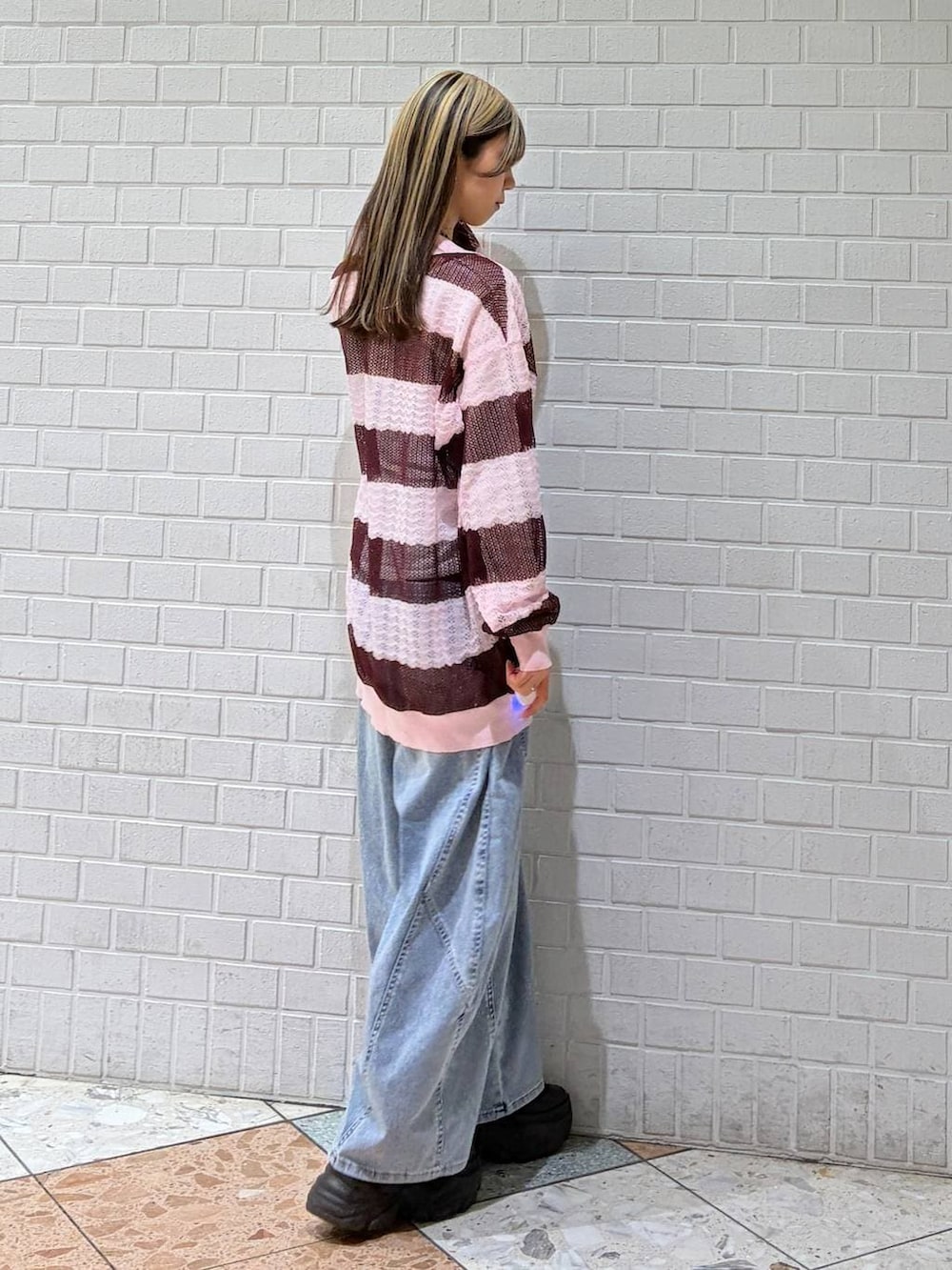 ブルー系のデニムパンツ、ピンク系のポロシャツを着用したレディースの春コーディネートの3枚目の写真