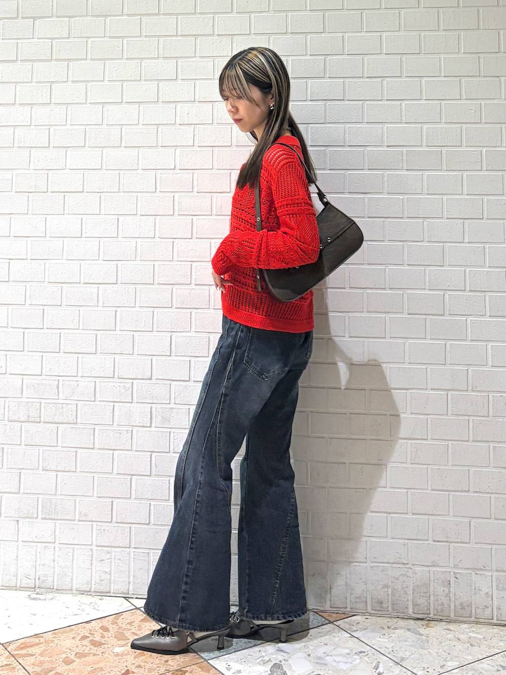 ブルー系のデニムパンツ、ブラウン系のハンドバッグ、ブラウン系のサンダルを着用したレディースの春コーディネートの5枚目の写真