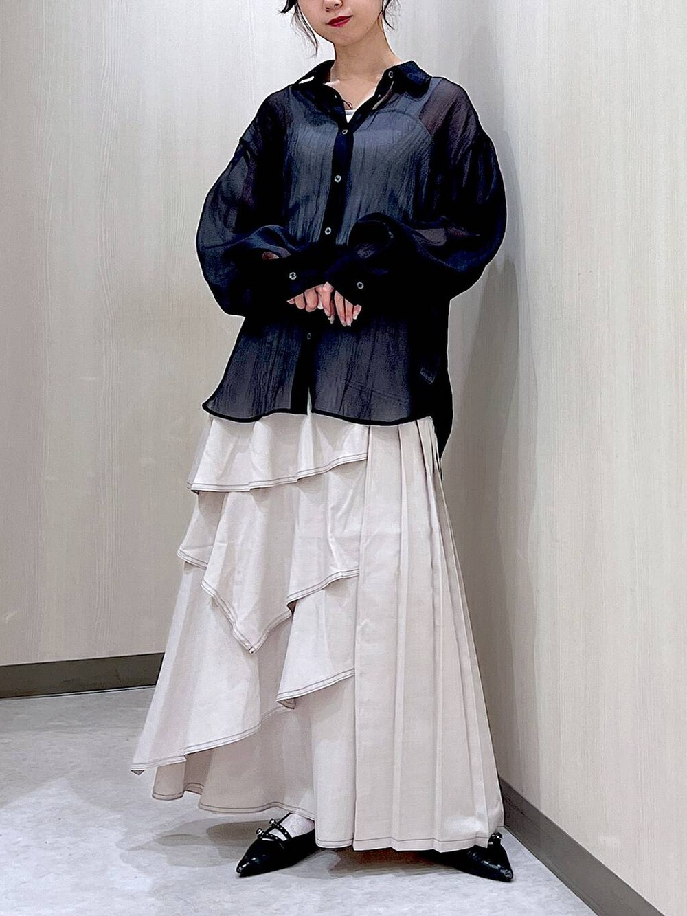 ブラック系のパンプス、ブラック系のシャツ/ブラウス、グレー系のスカートを着用したレディースの秋コーディネートの3枚目の写真