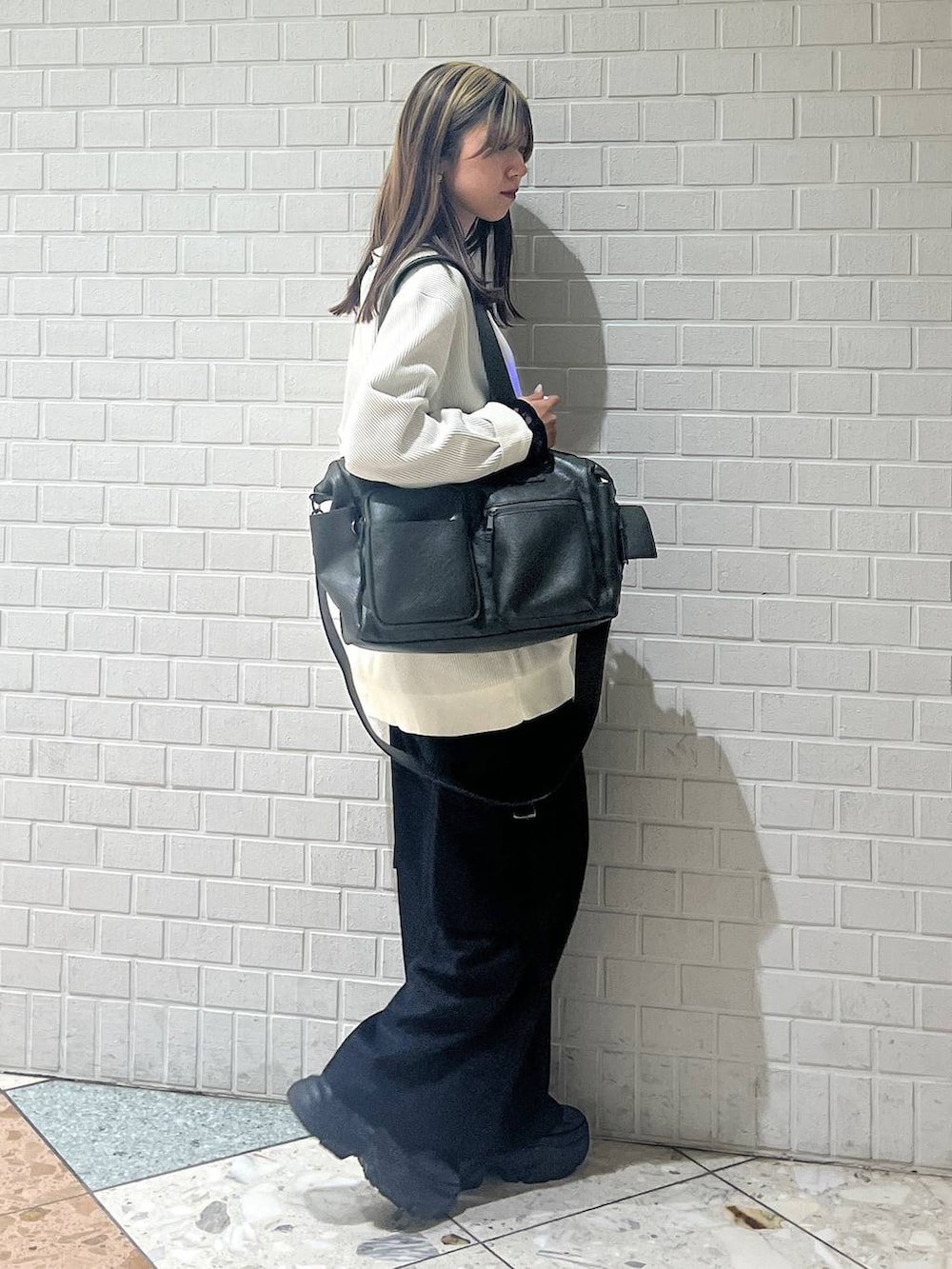 ブラック系のブーツ、グリーン系のボストンバッグ、ブラック系のTシャツ/カットソーを着用したレディースの秋コーディネートの4枚目の写真