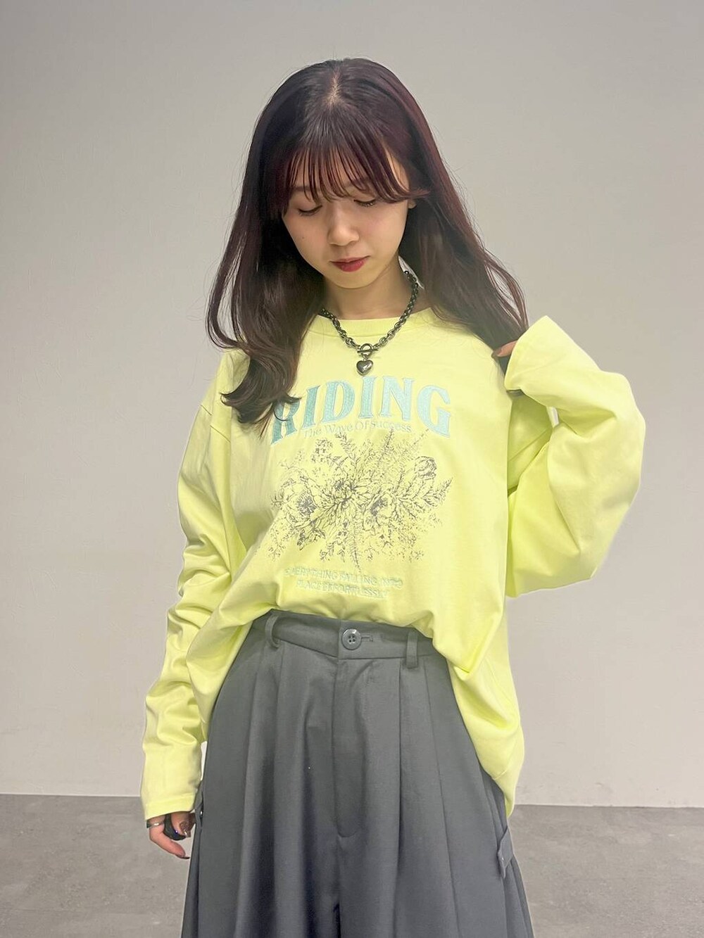 グレー系のカーゴパンツ、イエロー系のTシャツ/カットソー、ブラック系のネックレスを着用したレディースの冬コーディネートの2枚目の写真