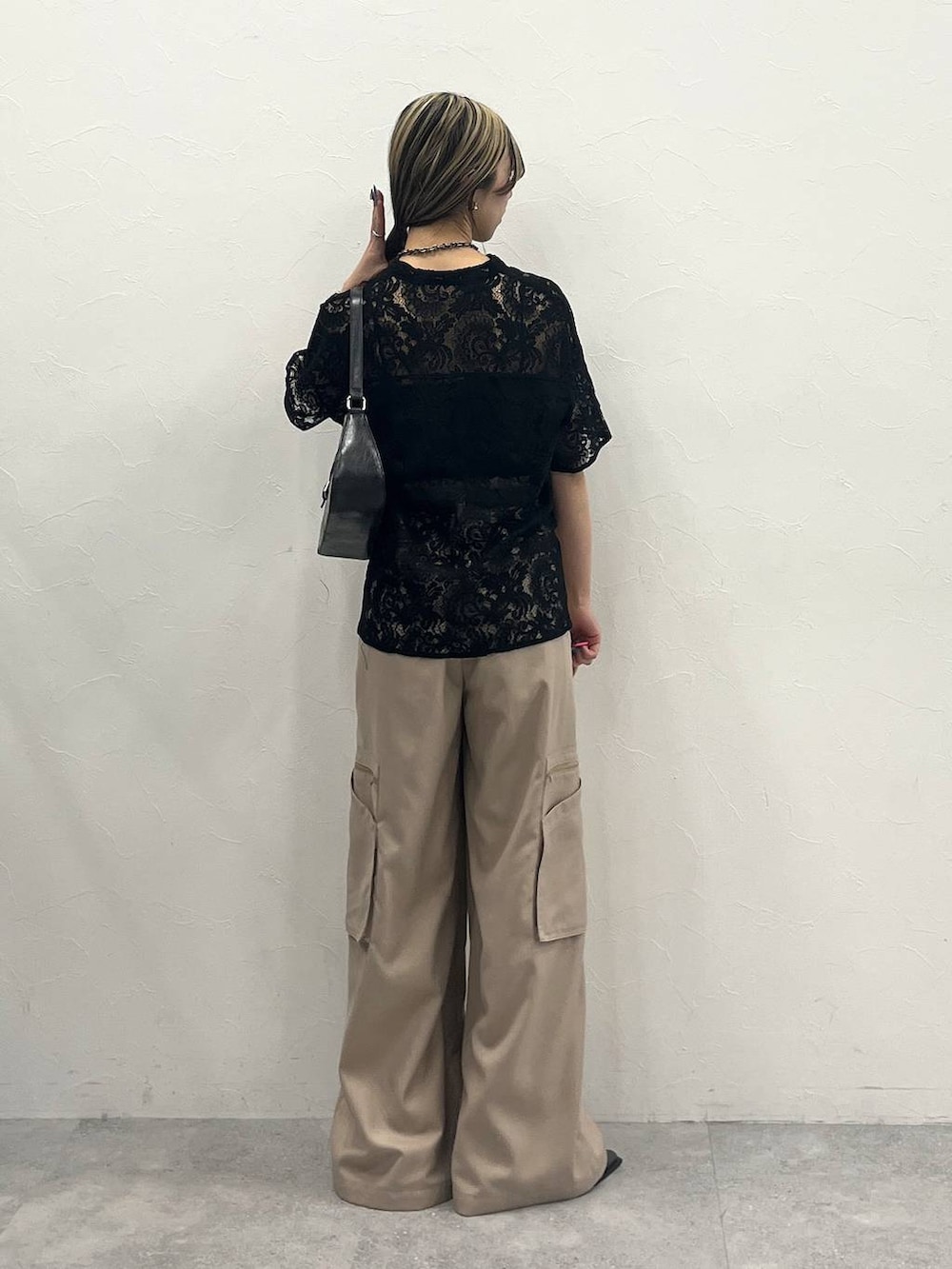 ブラック系のシャツ/ブラウス、ベージュ系のスラックス、ブラック系のハンドバッグを着用したレディースの春コーディネートの4枚目の写真