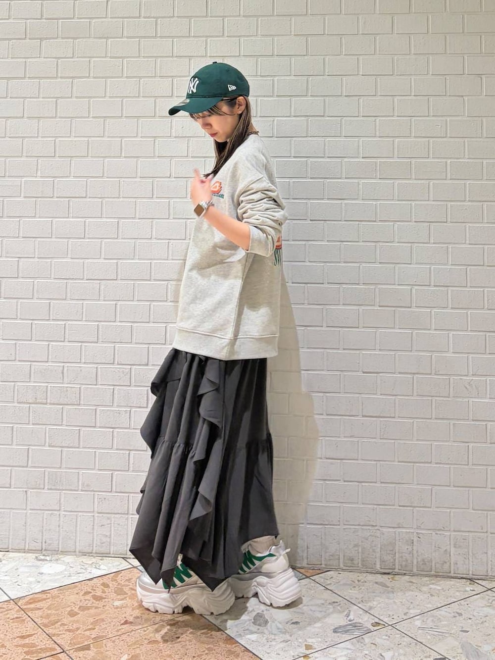 ホワイト系のスニーカー、グレー系のスカート、グレー系のスウェットを着用したレディースの春コーディネートの3枚目の写真