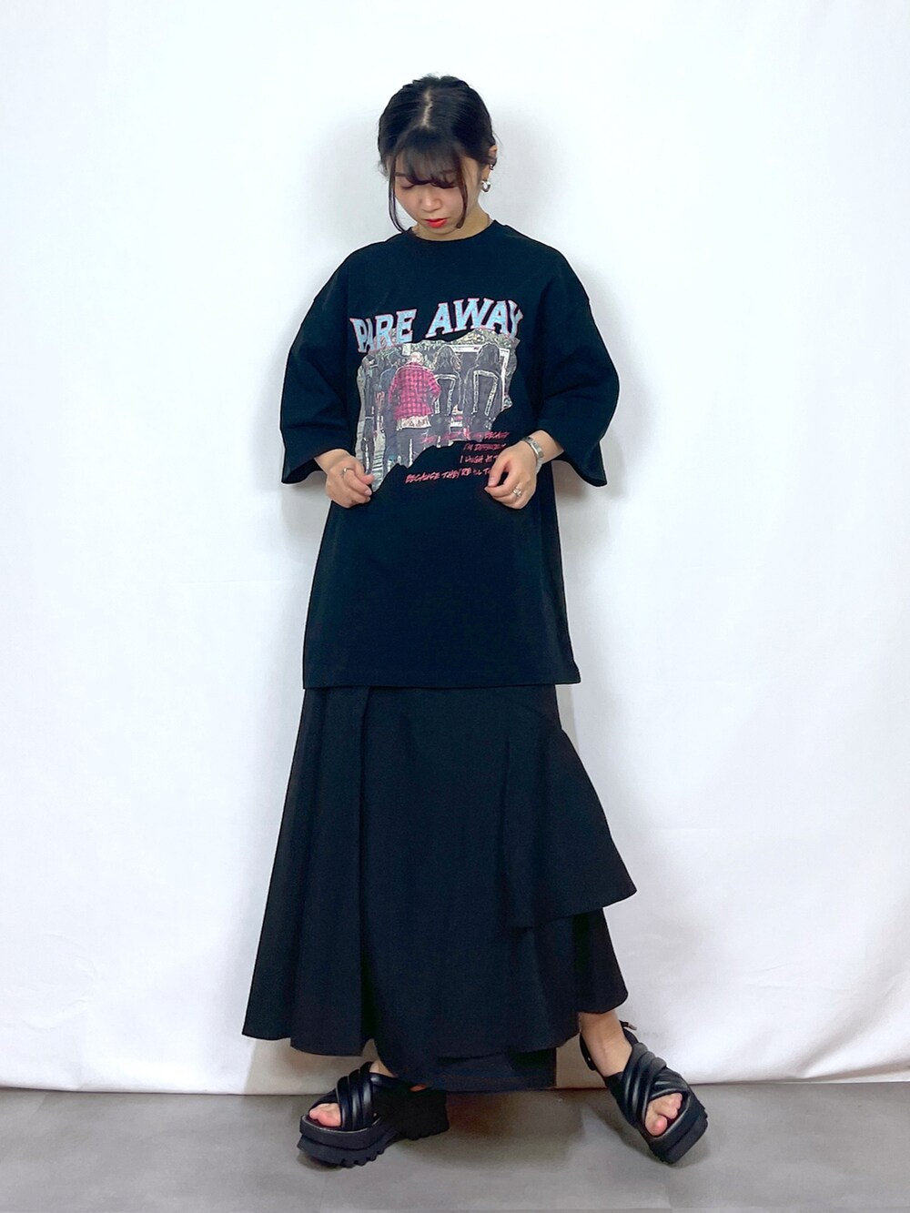 ブラック系のTシャツ/カットソー、ブラック系のスカート、ブラック系のサンダルを着用したレディースの春コーディネートの3枚目の写真