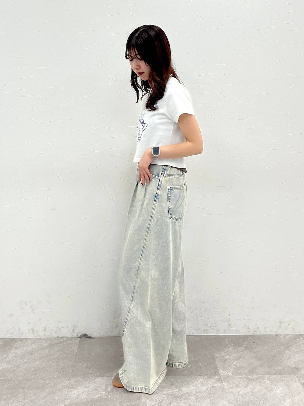 ブルー系のデニムパンツ、ホワイト系のTシャツ/カットソー、ブラウン系のベルトを着用したレディースの春コーディネートの2枚目の写真