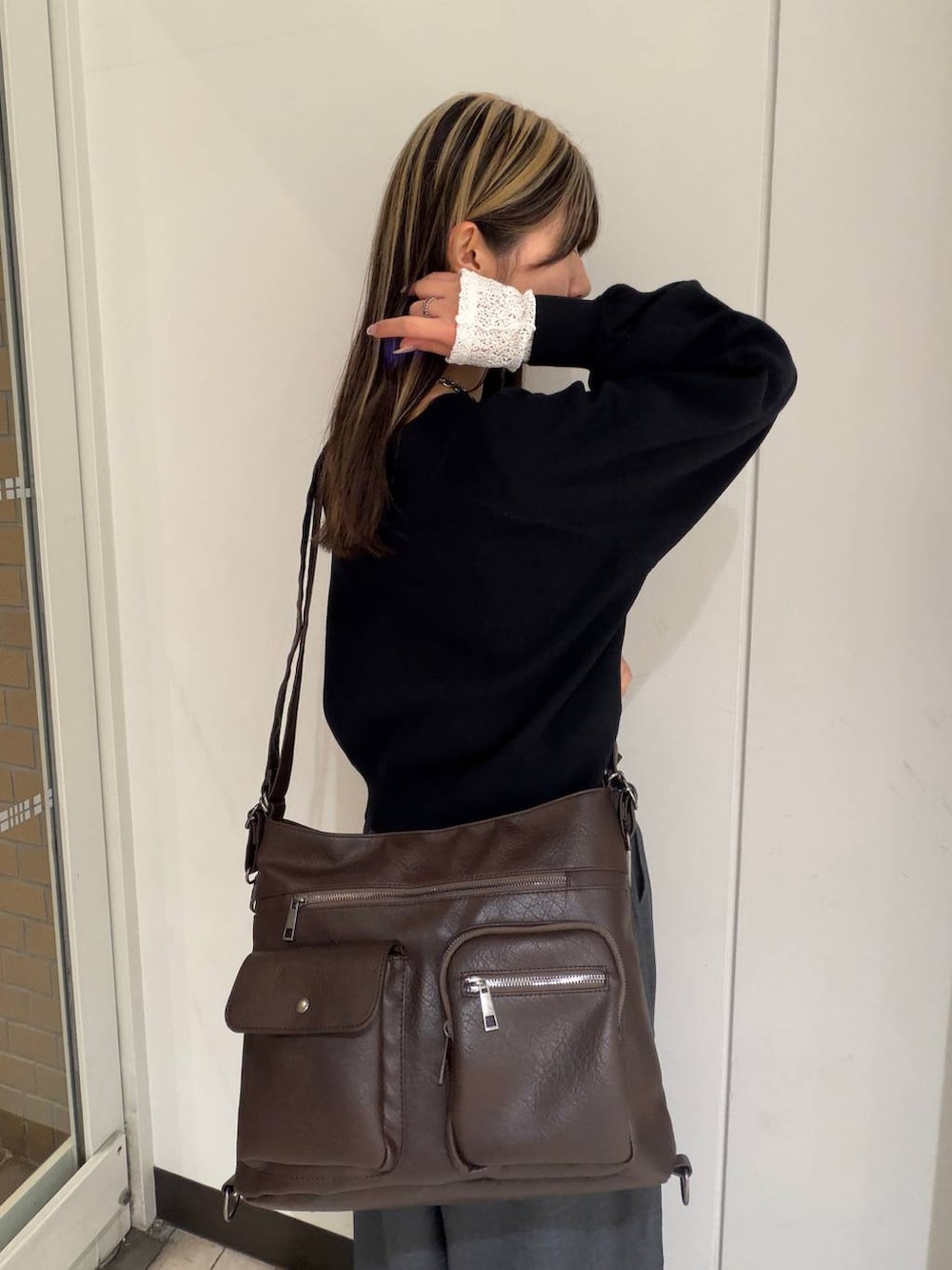 ブラック系のブーツ、ブラック系のニット/セーター、ブラウン系のショルダーバッグを着用したレディースの冬コーディネートの6枚目の写真