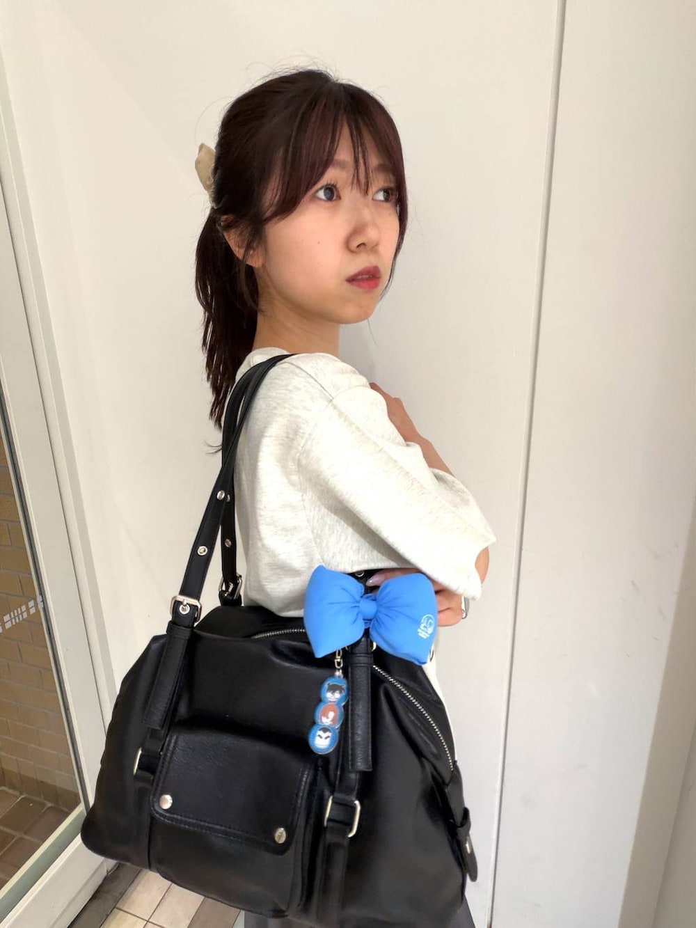 グレー系のスカート、ブラック系のボストンバッグ、ホワイト系のTシャツ/カットソーを着用したレディースの春コーディネートの3枚目の写真