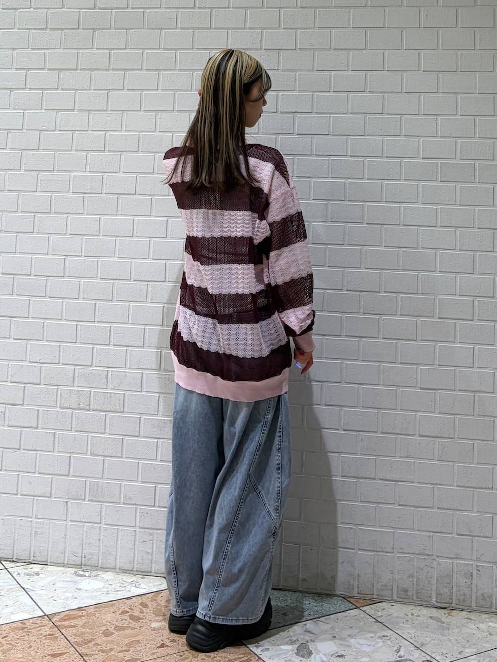 ブルー系のデニムパンツ、ピンク系のポロシャツを着用したレディースの春コーディネートの6枚目の写真