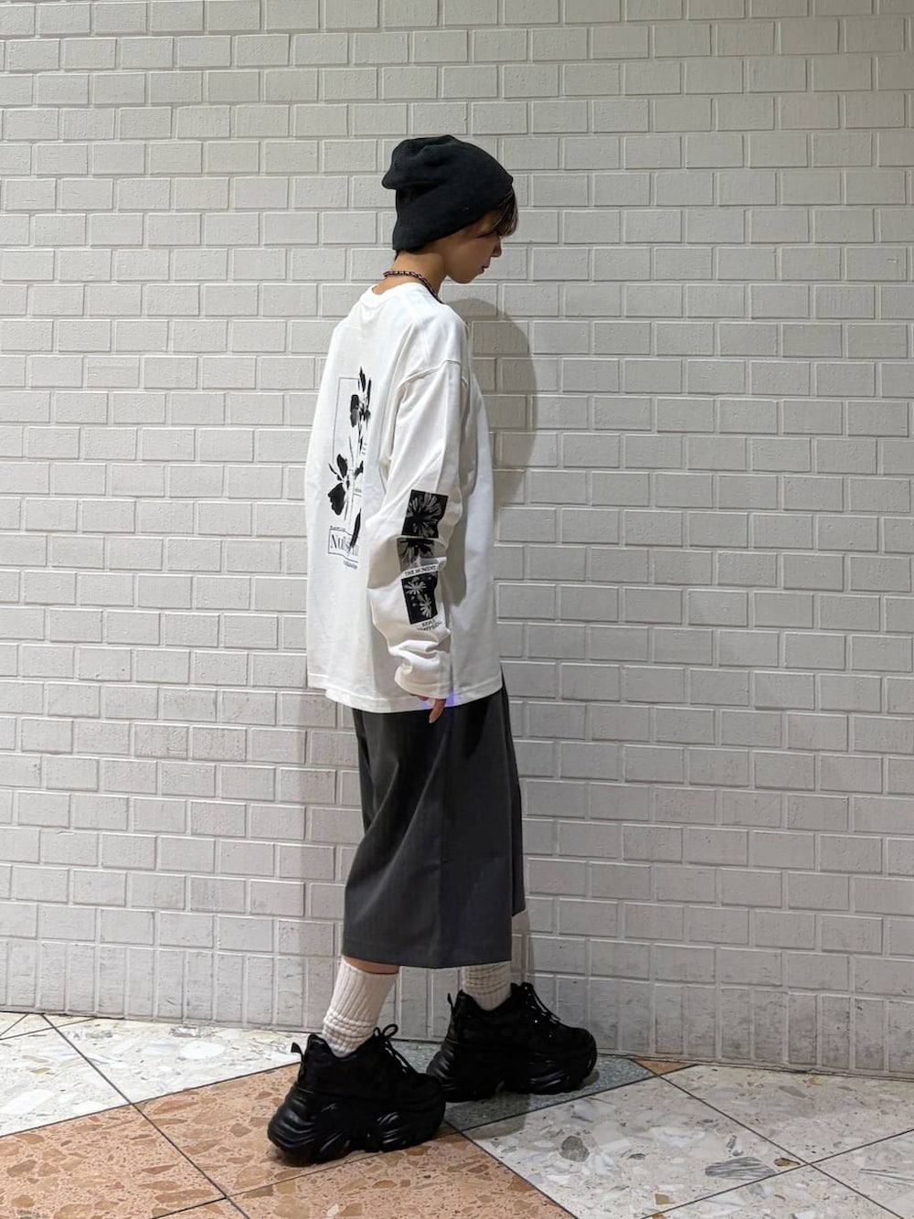 ブラック系のスニーカー、ホワイト系のTシャツ/カットソー、グレー系のスラックスを着用したレディースの春コーディネートの5枚目の写真