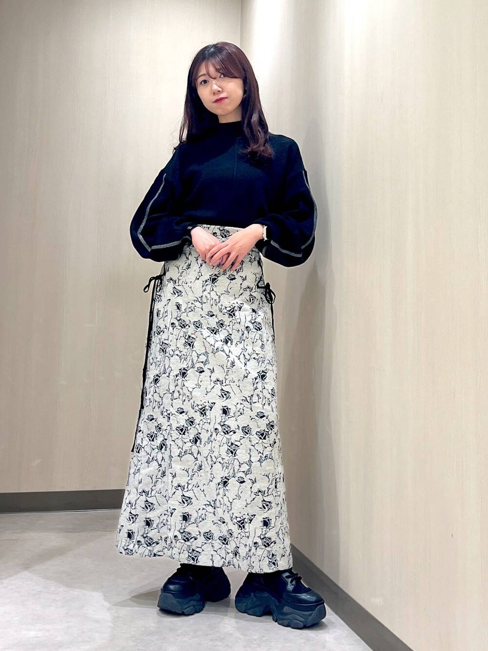 ブラック系のブーツ、ホワイト系のカーディガン/ボレロ、ブラック系のニット/セーターを着用したレディースの秋コーディネートの3枚目の写真