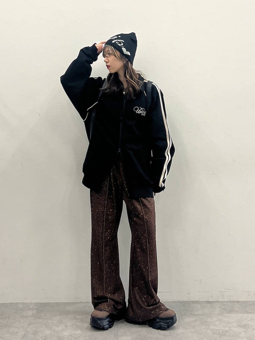 ブラウン系のブーツ、ブラック系のショルダーバッグ、ブラック系のジャージを着用したレディースの冬コーディネートの5枚目の写真