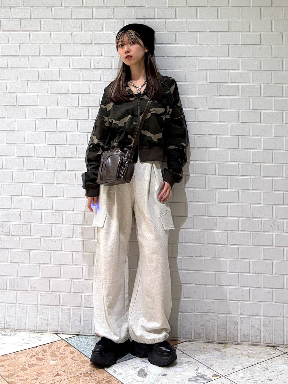 ブラック系のブーツ、ブラウン系のショルダーバッグ、グリーン系のジャージを着用したレディースの春コーディネートの4枚目の写真