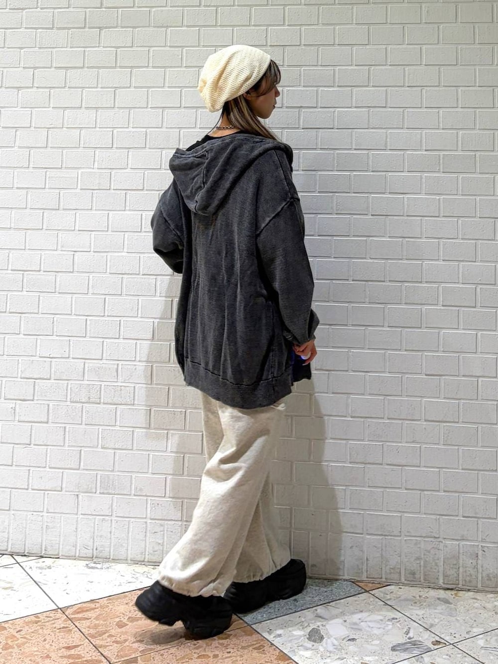 ブラック系のブーツ、グレー系のパーカー、ブラック系のTシャツ/カットソーを着用したレディースの春コーディネートの6枚目の写真