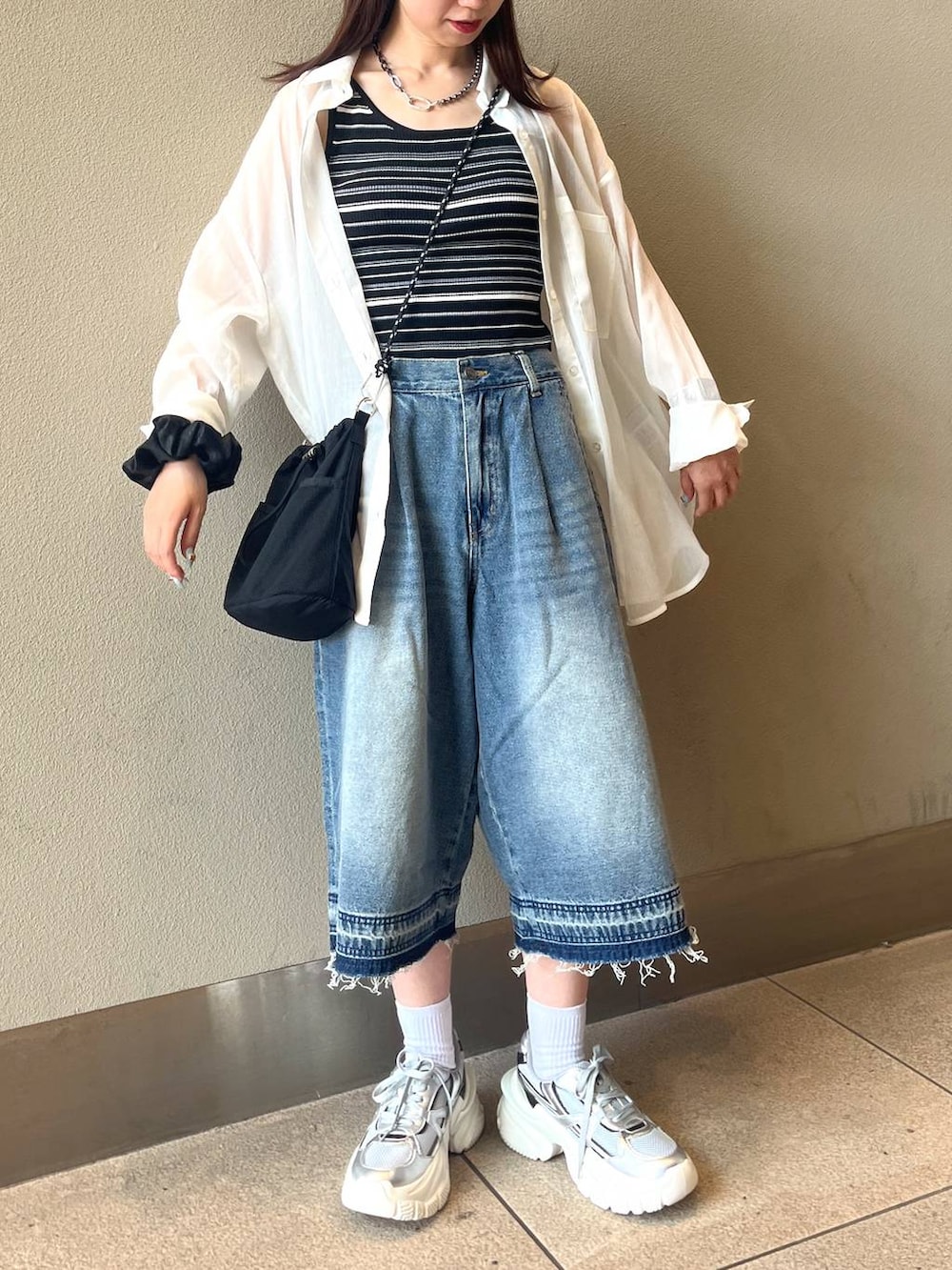 ホワイト系のシャツ/ブラウス、シルバー系のスニーカー、ブラック系のTシャツ/カットソーを着用したレディースの夏コーディネートの3枚目の写真