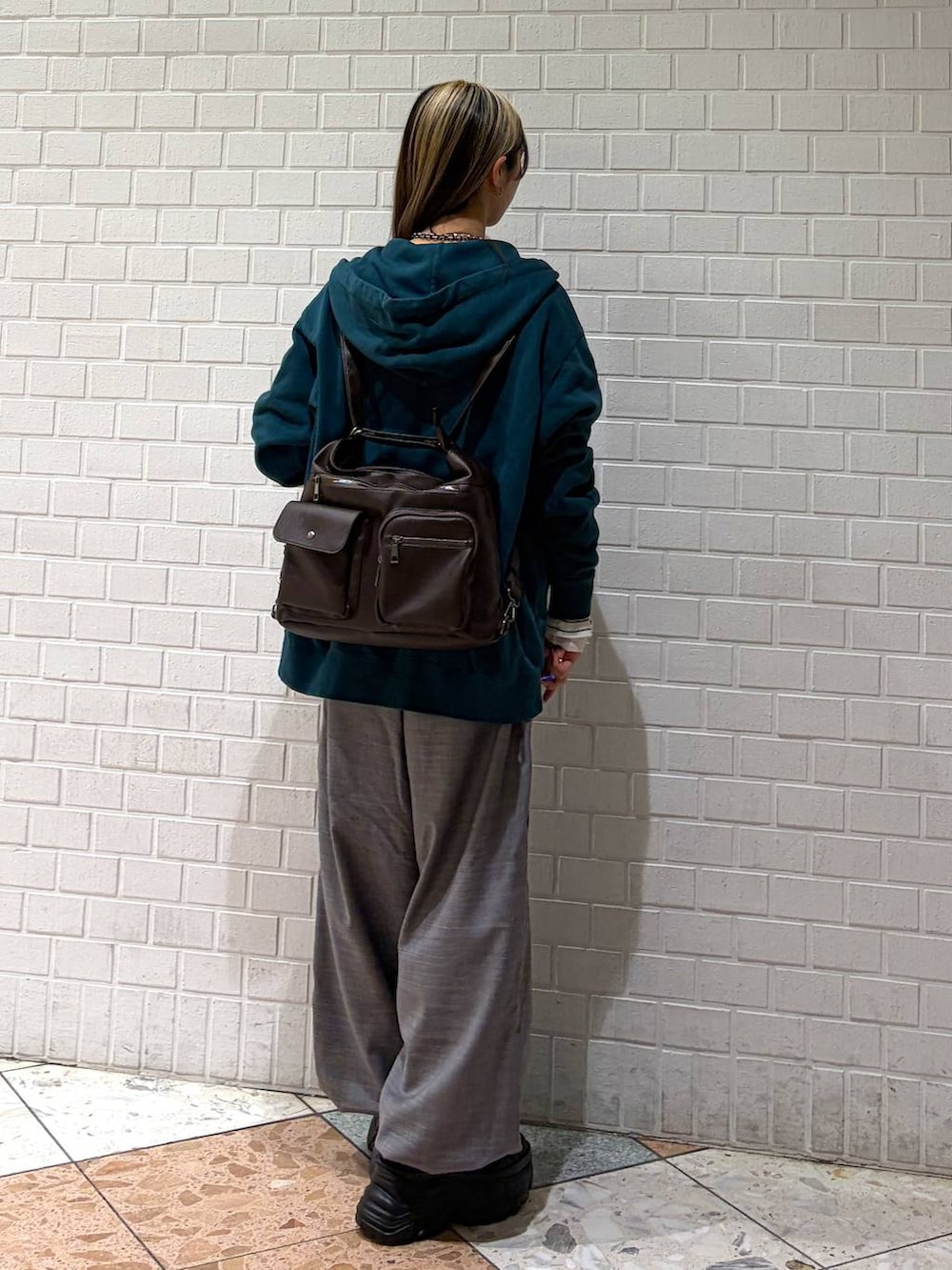 ブラック系のブーツ、グリーン系のパーカー、ブラウン系のショルダーバッグを着用したレディースの冬コーディネートの5枚目の写真