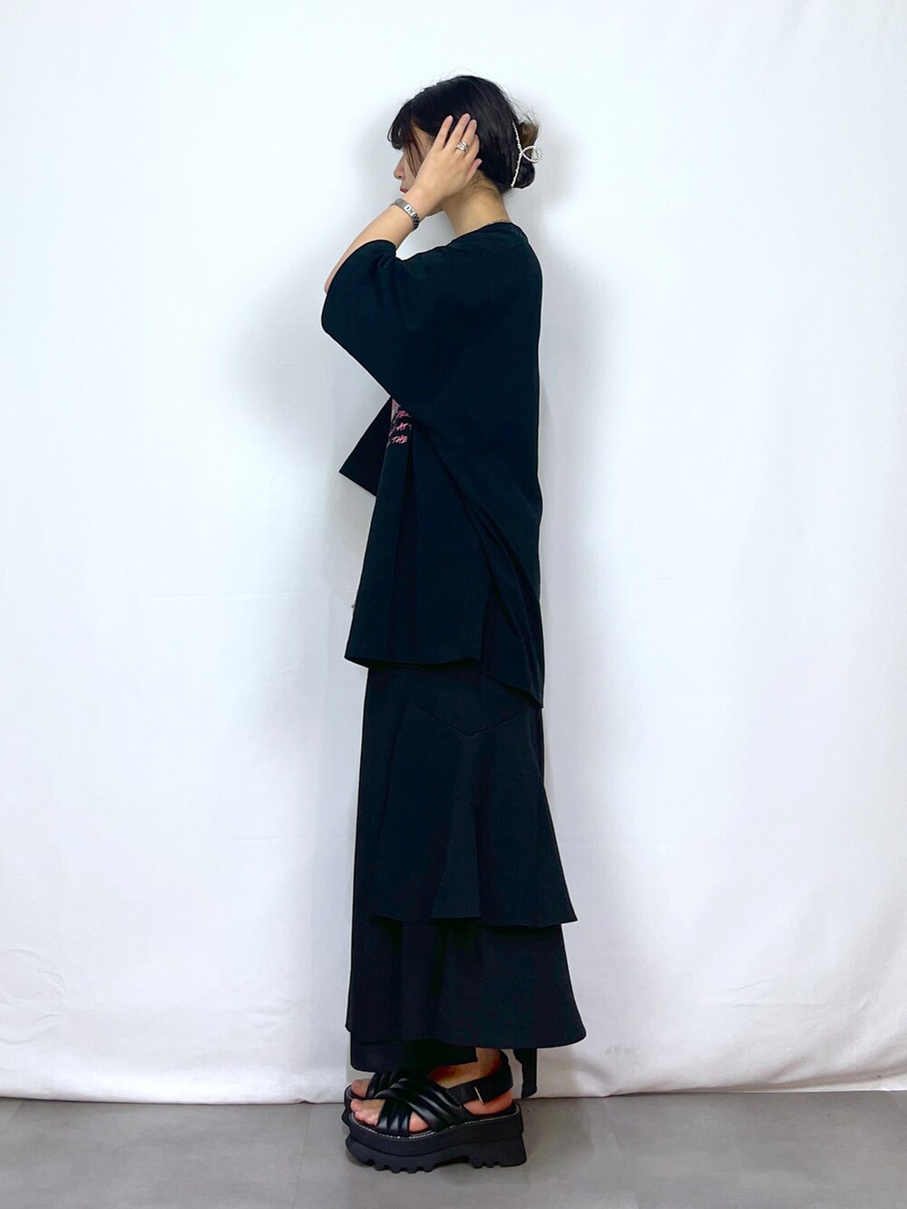 ブラック系のTシャツ/カットソー、ブラック系のスカート、ブラック系のサンダルを着用したレディースの春コーディネートの4枚目の写真