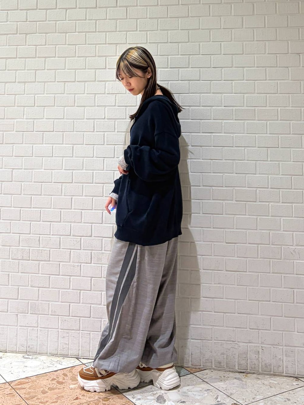 ベージュ系のスニーカー、ブルー系のパーカー、グレー系のその他パンツを着用したレディースの春コーディネートの5枚目の写真