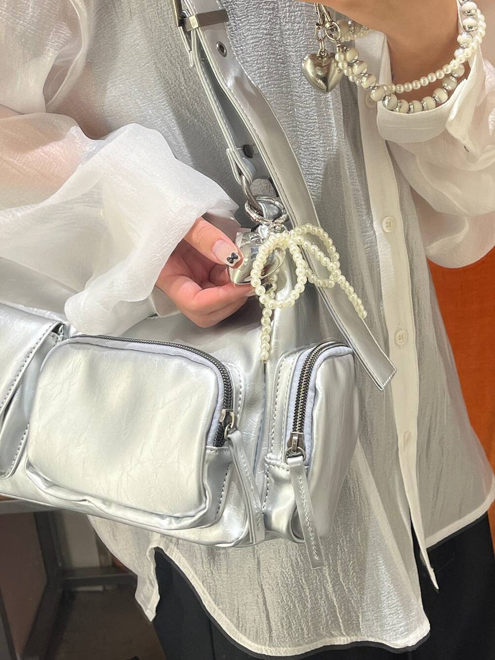 ホワイト系のシャツ/ブラウス、シルバー系のショルダーバッグ、シルバー系のネックレスを着用したレディースの秋コーディネートの2枚目の写真