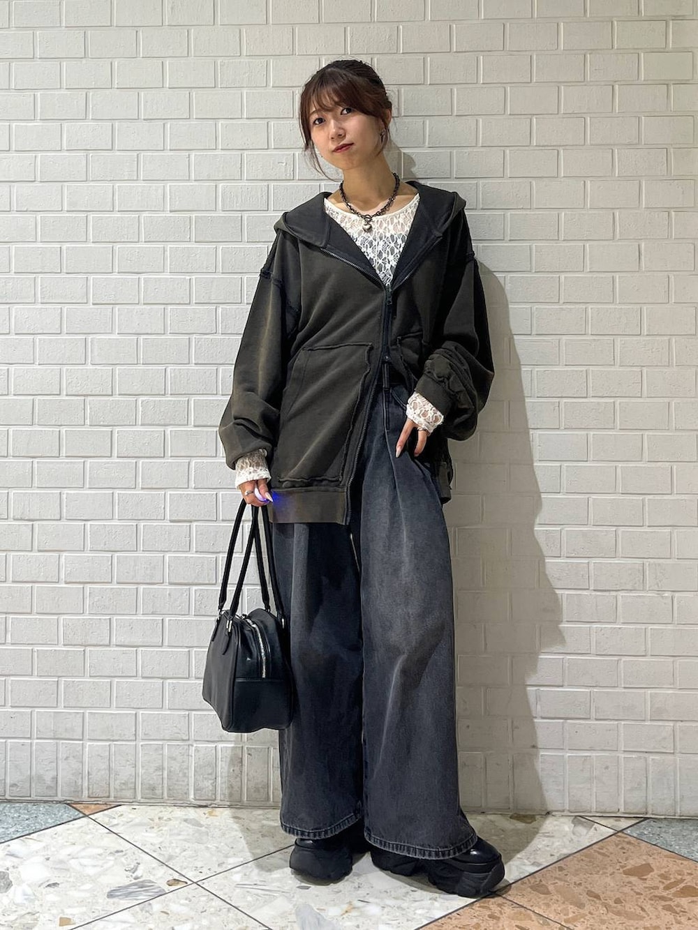 ブラック系のブーツ、ブラック系のデニムパンツ、ホワイト系のTシャツ/カットソーを着用したレディースの秋コーディネートの4枚目の写真