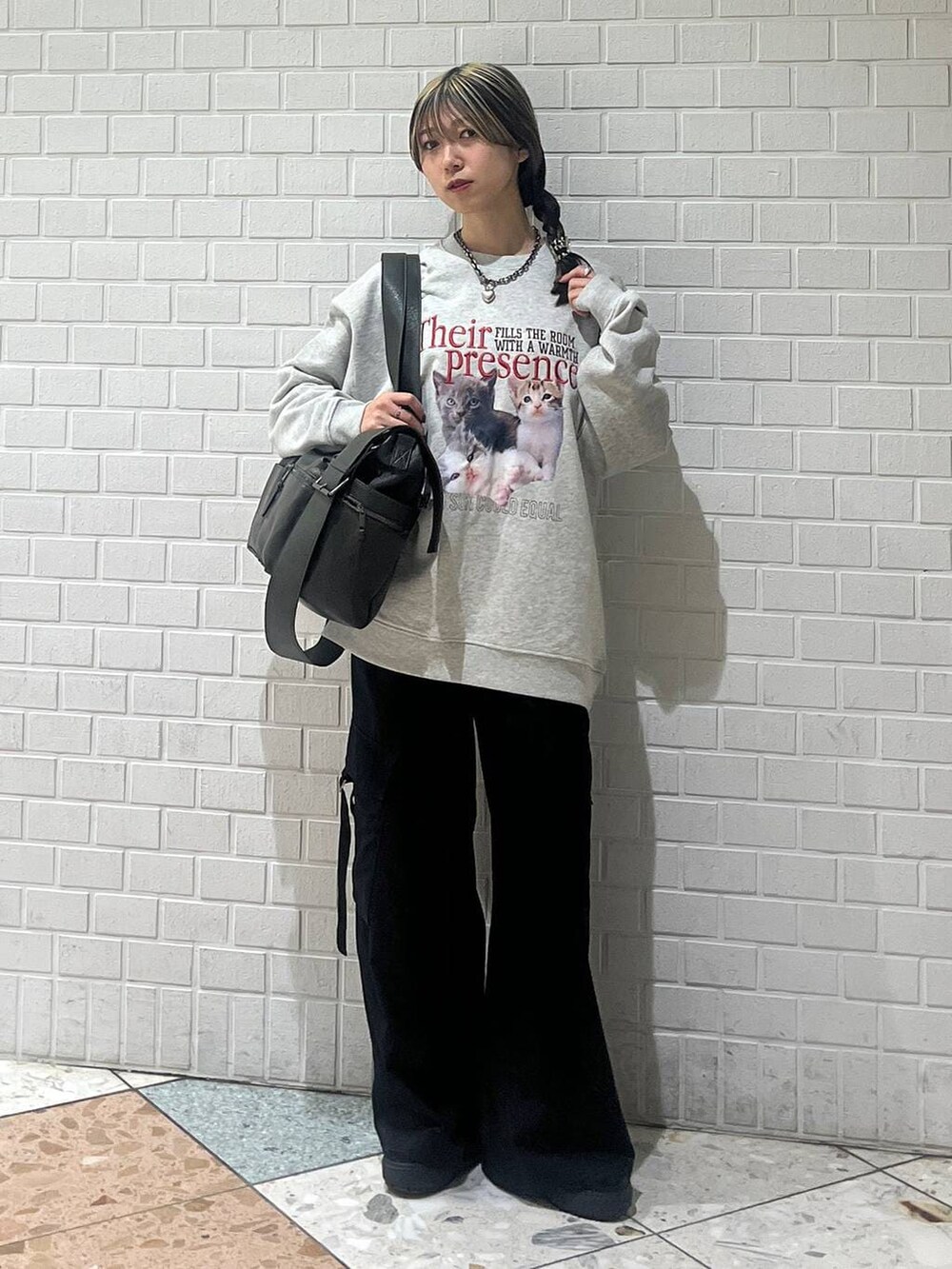 グリーン系のボストンバッグ、ブラック系のスラックス、グレー系のスウェットを着用したレディースの冬コーディネートの7枚目の写真